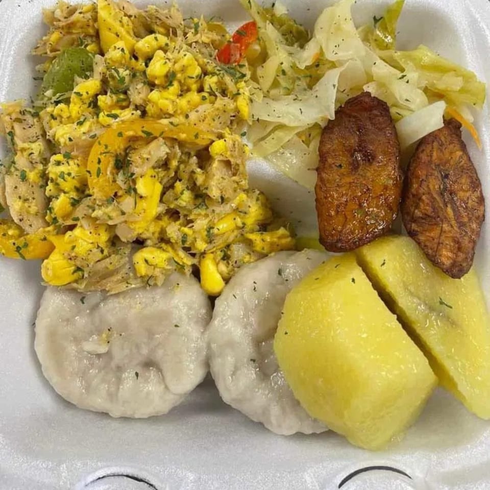 A Jamaican breakfast with ackee and saltfish, boiled dumplings, boiled banana, fried plantains, and steamed cabbage.