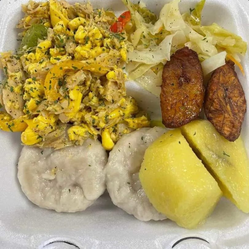 A Jamaican breakfast with ackee and saltfish, boiled dumplings, boiled banana, fried plantains, and steamed cabbage.